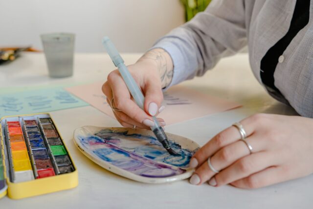 Două fotolii așezate față în față într-un cabinet de psihoterapie liniștit, cu o măsuță și o plantă