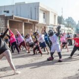 Doi alergători care fac exerciții de încălzire într-un parc, dimineața, înainte de alergare